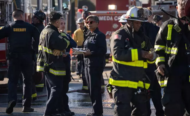 First responders and Pacific Gas &amp; Electric Co. workers at the site of the explosion on the 800 block of East Lewelling Boulevard, Thursday, Dec. 11, 2025, in Hayward, Calif. (AP Photo/Minh Connors)
