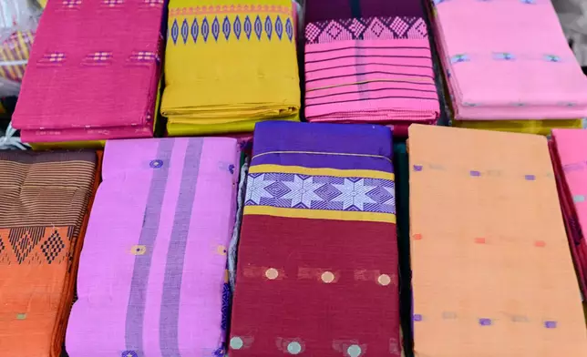 Tangail saris are displayed for sale at a weekly wholesale market in Tangail District, Bangladesh, Nov. 5, 2025. (AP Photo/Mahmud Hossain Opu)
