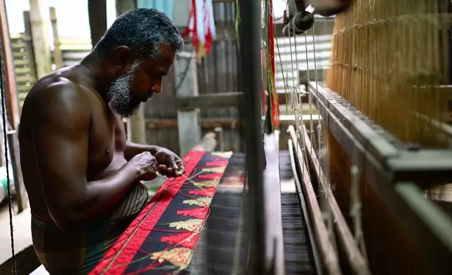 A weaver crafts a Tangail saree on a traditional hand-operated loom at a weaving workshop in Tangail District, Bangladesh, Nov. 5, 2025. (AP Photo/Mahmud Hossain Opu)