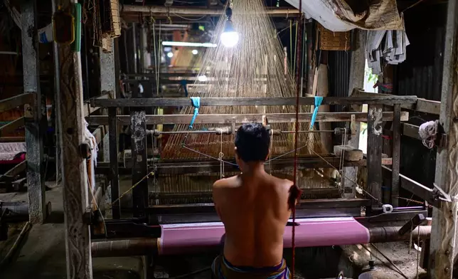 A weaver crafts a Tangail saree on a traditional hand-operated loom at a weaving workshop in Tangail District, Bangladesh, Nov. 5, 2025. (AP Photo/Mahmud Hossain Opu)