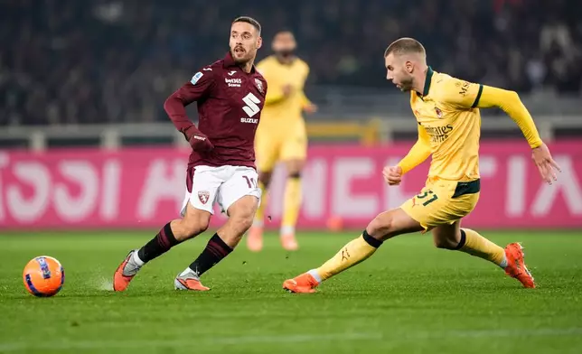 Torino's Nikola Vlasic fights for the ball with AC Milan's Strahinja Pavlovic during the Serie A soccer match between Torino FC and Milan in Turin, Italy, Monday, Dec. 8, 2025. (Fabio Ferrari/LaPresse via AP)