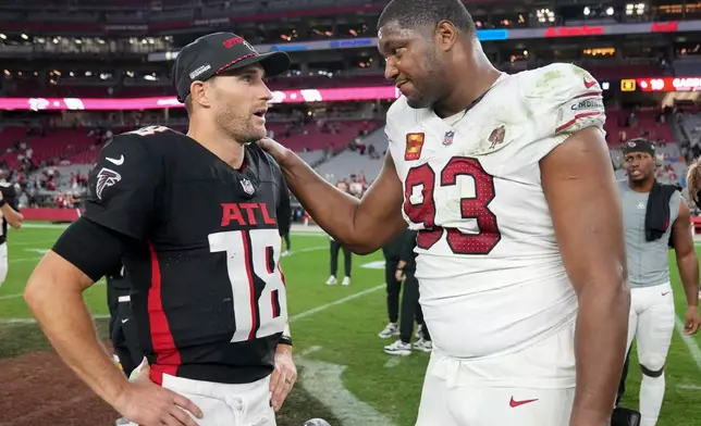 Atlanta Falcons quarterback Kirk Cousins (18) and Arizona Cardinals defensive tackle Calais Campbell (93) speak after an NFL football game, Sunday, Dec. 21, 2025, in Glendale, Ariz. (AP Photo/Rick Scuteri)