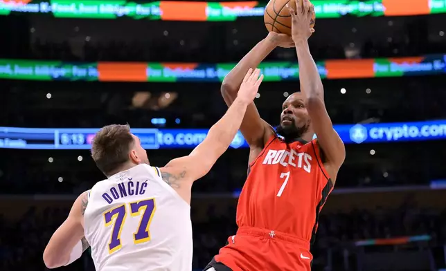 Los Angeles Lakers guard Luka Doncic (77) defends a shot by Houston Rockets forward Kevin Durant during the first half of an NBA basketball game, Thursday, Dec. 25, 2025, in Los Angeles. (AP Photo/Jayne Kamin-Oncea)