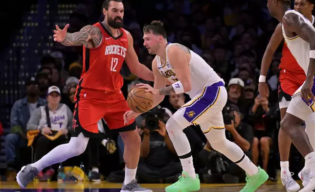 Houston Rockets center Steven Adams (12) guards Los Angeles Lakers guard Luka Doncic during the first half of an NBA basketball game, Thursday, Dec. 25, 2025, in Los Angeles. (AP Photo/Jayne Kamin-Oncea)