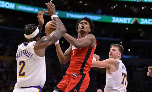 Houston Rockets guard Amen Thompson drives past Los Angeles Lakers forward Jarred Vanderbilt (2) and Lakers' guard Luka Doncic for a basket during the first half of an NBA basketball game, Thursday, Dec. 25, 2025, in Los Angeles. (AP Photo/Jayne Kamin-Oncea)
