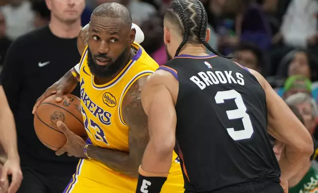Los Angeles Lakers forward Lebron James squares up to Phoenix Suns forward Dillon Brooks (3) during the first half of an NBA basketball game, Tuesday, Dec. 23, 2025, in Phoenix. (AP Photo/Rick Scuteri)