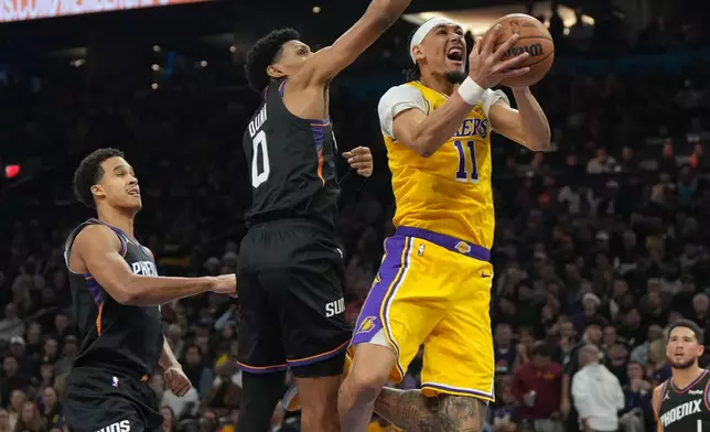 Los Angeles Lakers center Jaxson Hayes (11) gets fouled by Phoenix Suns forward Ryan Dunn (0) during the first half of an NBA basketball game, Tuesday, Dec. 23, 2025, in Phoenix. (AP Photo/Rick Scuteri)