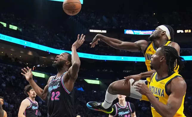 Miami Heat forward Andrew Wiggins (22) attempts a shot as Indiana Pacers forward Jarace Walker, right, rear, defends during the first half of an NBA basketball game, Saturday, Dec. 27, 2025, in Miami. (AP Photo/Lynne Sladky)