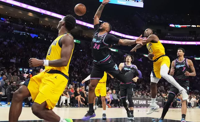 Miami Heat guard Norman Powell (24) loses control of the ball as Indiana Pacers guard Aaron Nesmith (23) defends during the first half of an NBA basketball game, Saturday, Dec. 27, 2025, in Miami. (AP Photo/Lynne Sladky)