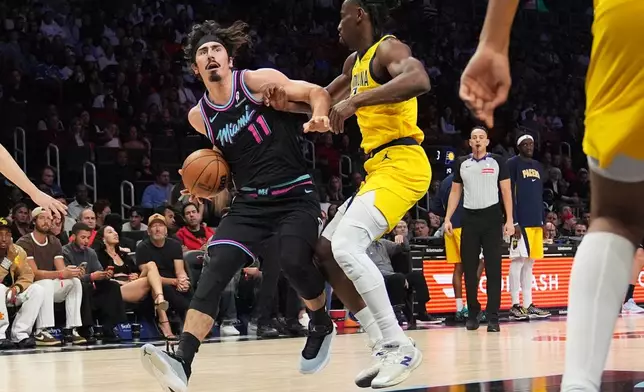 Miami Heat forward Jaime Jaquez Jr. (11) drives to the basket as Indiana Pacers guard Aaron Nesmith, right, defends during the first half of an NBA basketball game, Saturday, Dec. 27, 2025, in Miami. (AP Photo/Lynne Sladky)