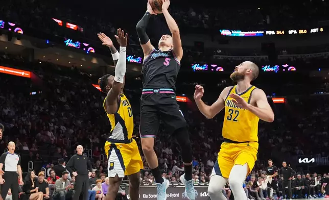 Miami Heat forward Nikola Jovic (5) goes to the basket as Indiana Pacers guard Bennedict Mathurin, left, and center Jay Huff (32) defend during the first half of an NBA basketball game, Saturday, Dec. 27, 2025, in Miami. (AP Photo/Lynne Sladky)