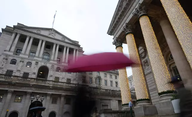 Pedestrians pass the Bank of England in London, as the Monetary Policy Committee (MPC) will publish their decision on interest rates, Thursday, Dec. 18, 2025. (AP Photo/Kirsty Wigglesworth)
