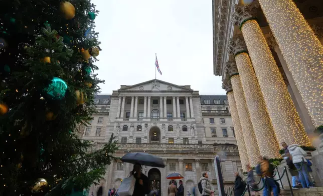 Pedestrians pass the Bank of England in London, as the Monetary Policy Committee (MPC) will publish their decision on interest rates, Thursday, Dec. 18, 2025. (AP Photo/Kirsty Wigglesworth)