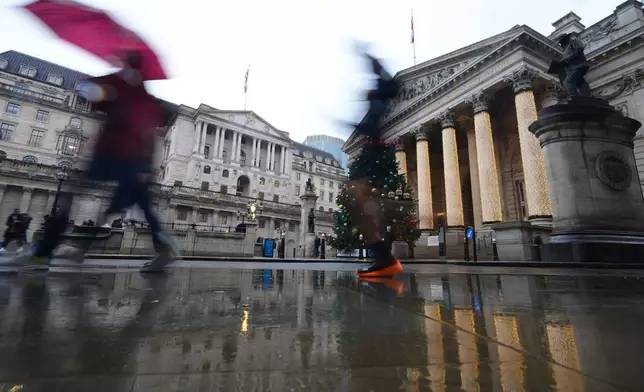 Pedestrians pass the Bank of England in London, as the Monetary Policy Committee (MPC) will publish their decision on interest rates, Thursday, Dec. 18, 2025. (AP Photo/Kirsty Wigglesworth)