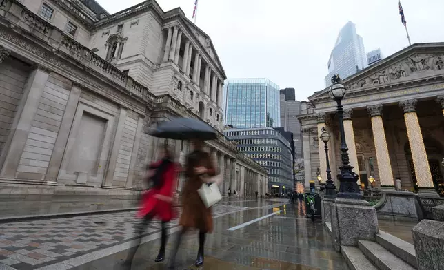 Pedestrians pass the Bank of England in London, a the Monetary Policy Committee (MPC) will publish their decision on interest rates, Thursday, Dec. 18, 2025. (AP Photo/Kirsty Wigglesworth)
