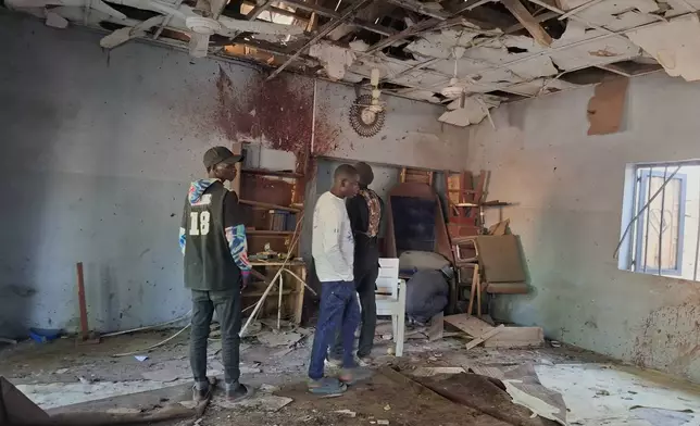 People inspect the scene of a deadly bomb explosion inside a mosque in Maiduguri, Nigeria, Thursday, Dec. 25, 2025. (AP Photo/Jossy Ola )