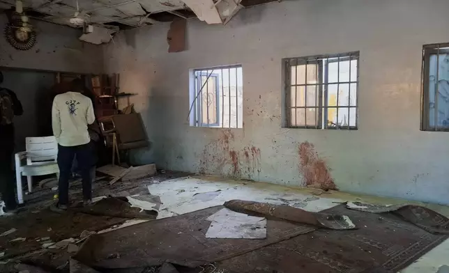 A man inspects the scene of a deadly bomb explosion inside a mosque in Maiduguri, Nigeria, Thursday, Dec. 25, 2025. (AP Photo/Jossy Ola)