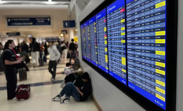 A departure board lists delayed and cancelled flights at O'Hare International Airport, Sunday, Nov. 30, 2025, in Chicago. (AP Photo/Adam Schreck)
