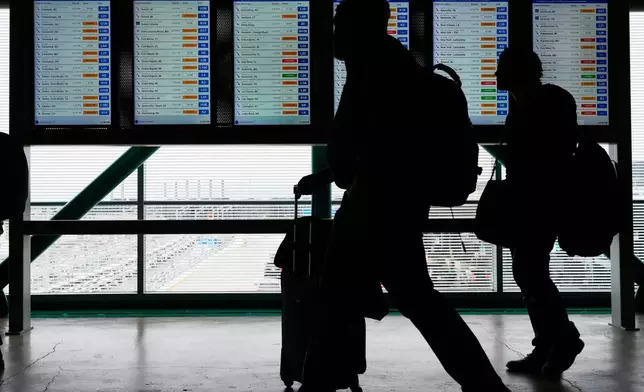 Travelers walk though the terminal at O'Hare International Airport, in Chicago, Sunday, Nov. 30, 2025. (AP Photo/Nam Y. Huh)