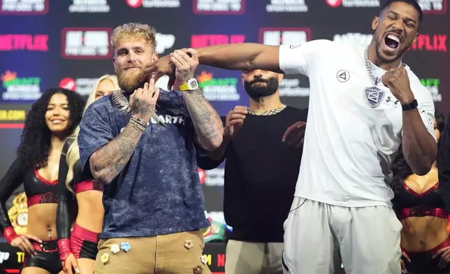 Jake Paul, left, and Anthony Joshua face off during a news conference promoting their upcoming heavyweight boxing match, Wednesday, Dec. 17, 2025, in Miami Beach, Fla. (AP Photo/Lynne Sladky)