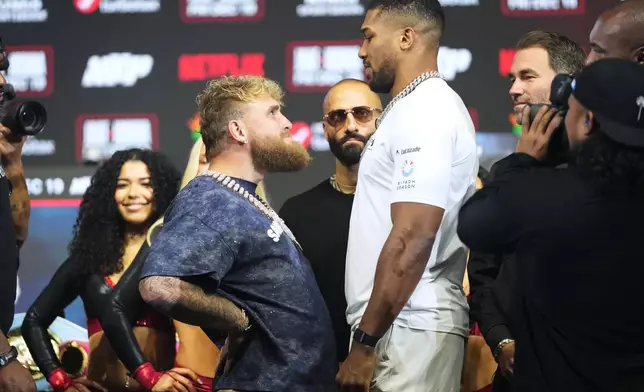Jake Paul, left, and Anthony Joshua face off during a news conference promoting their upcoming heavyweight boxing match, Wednesday, Dec. 17, 2025, in Miami Beach, Fla. (AP Photo/Lynne Sladky)