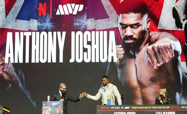 Anthony Joshua, right, is introduced during a news conference promoting his upcoming heavyweight boxing match against Jake Paul, Wednesday, Dec. 17, 2025, in Miami Beach, Fla. (AP Photo/Lynne Sladky)