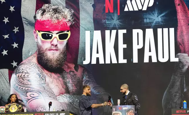 Jake Paul, center, attends a news conference promoting his upcoming heavyweight boxing match against Anthony Joshua, Wednesday, Dec. 17, 2025, in Miami Beach, Fla. (AP Photo/Lynne Sladky)