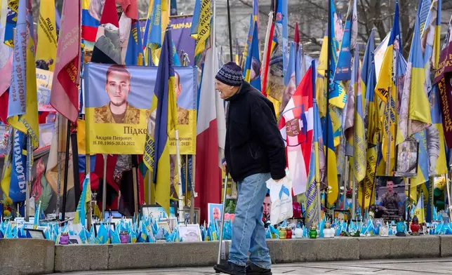 A man walks around an improvised memorial to fallen soldiers killed in the Russia-Ukraine war at Independence square in Kyiv, Ukraine, Wednesday, Dec. 10, 2025. (AP Photo/Efrem Lukatsky)