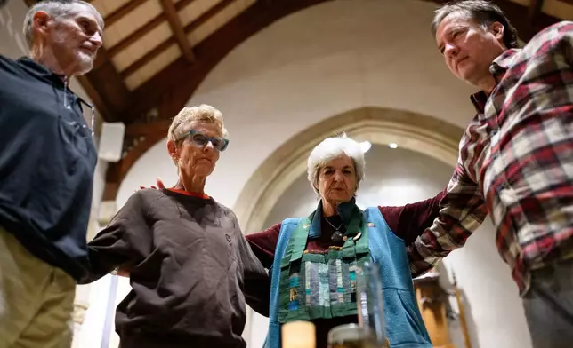 Participants form a circle to end an interfaith meditation practice at All Saints Episcopal Church in Pasadena, Calif., on Monday, Dec. 15, 2025. (AP Photo/William Liang)