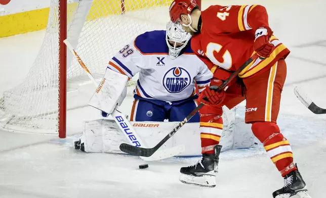 Edmonton Oilers goalie Connor Ingram (39) blocks the net against Calgary Flames' Adam Klapka during the third period of an NHL hockey game in Calgary, Alberta, Saturday, Dec. 27, 2025. (Jeff McIntosh/The Canadian Press via AP)