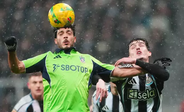 Fulham's Raul Jimenez, left, and Newcastle United's Tino Livramento battle for the ball during the English League Cup quarter final soccer match between Newcastle and Fulham in Newcastle upon Tyne, England, Wednesday, Dec. 17, 2025. (Owen Humphreys/PA via AP)