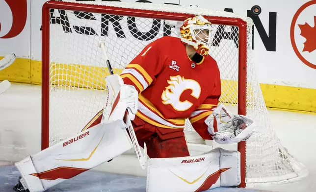 Calgary Flames goalie Devin Cooley stares down the puck during the third period of an NHL hockey game against the Vegas Golden Knights in Calgary, Alberta, Saturday, Dec. 20, 2025. (Jeff McIntosh/The Canadian Press via AP)