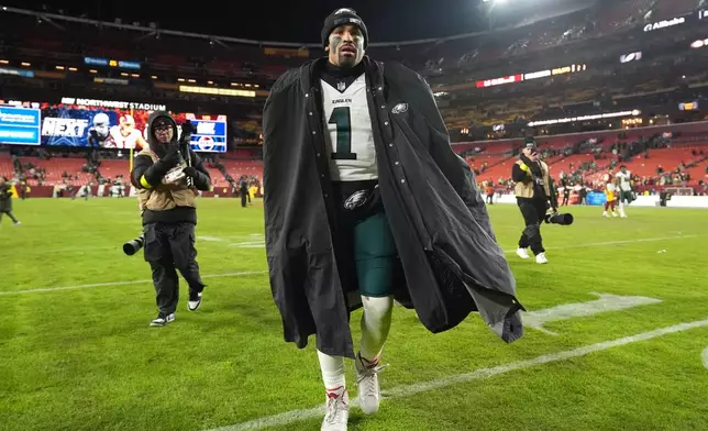 Philadelphia Eagles quarterback Jalen Hurts, center, leaves the field after a win over the Washington Commanders in an NFL football game, Saturday, Dec. 20, 2025, in Landover, Md. (AP Photo/Stephanie Scarbrough)