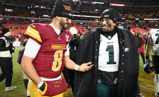 Washington Commanders quarterback Marcus Mariota (8) and Philadelphia Eagles quarterback Jalen Hurts (1) talk after an NFL football game, Thursday, Dec. 20, 2025, in Landover, Md. (AP Photo/Nick Wass)