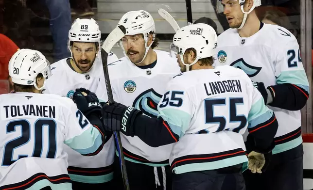 Seattle Kraken's Chandler Stephenson, centre, celebrates his goal with teammates during the second period of an NHL hockey game against the Calgary Flames, in Calgary, Alberta, Thursday, Dec. 18, 2025. (Jeff McIntosh/The Canadian Press via AP)