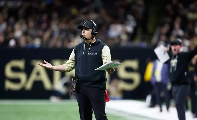 New Orleans Saints head coach Kellen Moore gestures on the field in the second half of an NFL football game against the Carolina Panthers, Sunday, Dec. 14, 2025, in New Orleans. (AP Photo/Butch Dill)