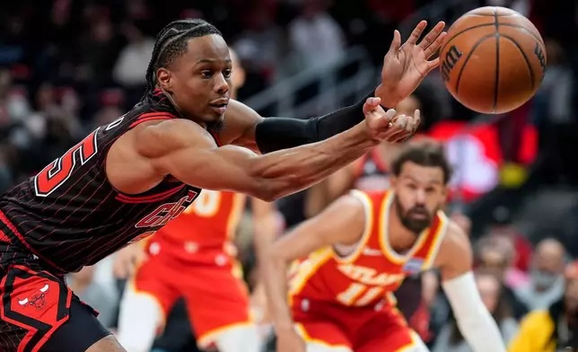Chicago Bulls forward Isaac Okoro (35) vies for a loose ball against the Atlanta Hawks during the first half of an NBA basketball game, Tuesday, Dec. 23, 2025, in Atlanta. (AP Photo/Mike Stewart)