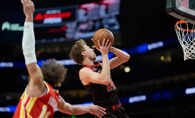 Chicago Bulls forward Matas Buzelis (14) drives past Atlanta Hawks guard Trae Young (11) during the first half of an NBA basketball game, Tuesday, Dec. 23, 2025, in Atlanta. (AP Photo/Mike Stewart)