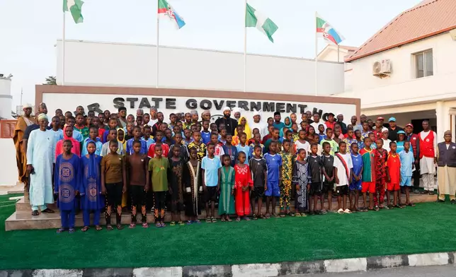 Government officials poses for photographs with Freed students of the St. Mary's Catholic School in the Papiri community at the government house in Minna, Nigeria, Monday, Dec. 8, 2025. (AP Photo)
