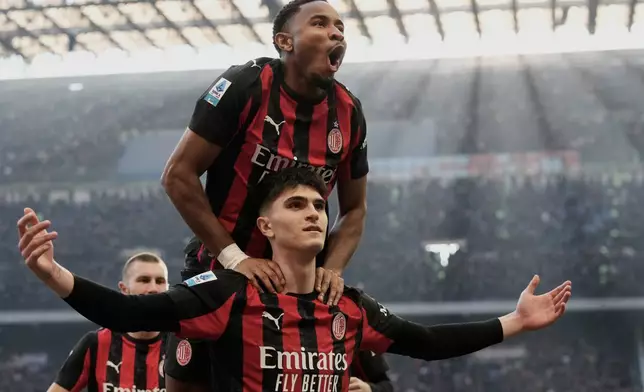 AC Milan's Davide Bartesaghi celebrates with AC Milan's Christopher Nkunku, top, after scoring his side's second goal during the Serie A soccer match between AC Milan and Sassuolo, in Milan, Italy, Sunday, Dec. 14, 2025. (AP Photo/Luca Bruno)