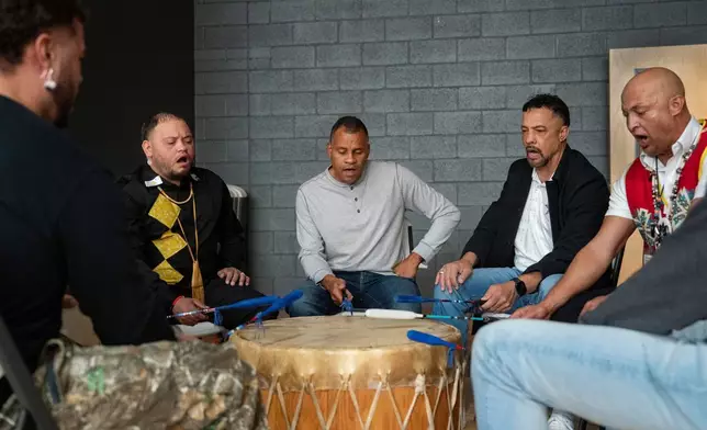 People sing while playing drums during a watch party hosted by the Lumbee Tribe of North Carolina, Wednesday, Dec. 17, 2025, in Pembroke, N.C. (AP Photo/Allison Joyce)
