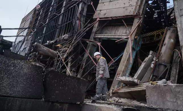 A worker walks in front of a production hall after a recent Russian missile attack at DTEK's power plant in Ukraine, on Wednesday, Dec. 10, 2025. (AP Photo/Evgeniy Maloletka)