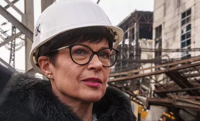 EU Commissioner for Enlargement Marta Kos looks at a production hall damaged after a recent Russian missile attack at DTEK's power plant in Ukraine, on Wednesday, Dec. 10, 2025. (AP Photo/Evgeniy Maloletka)