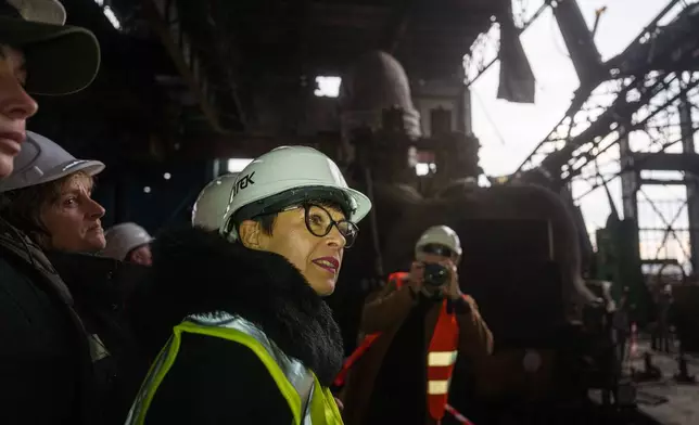 EU Commissioner for Enlargement Marta Kos looks at a production hall damaged after a recent Russian missile attack at DTEK's power plant in Ukraine, on Wednesday, Dec. 10, 2025. (AP Photo/Evgeniy Maloletka)