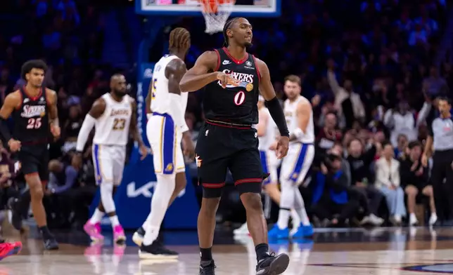 Philadelphia 76ers' Tyrese Maxey, center, reacts to his three-point shot during the first half of an NBA basketball game against the Los Angeles Lakers, Sunday, Dec. 7, 2025, in Philadelphia. (AP Photo/Chris Szagola)