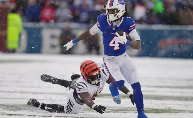 Buffalo Bills running back James Cook III (4) runs with the ball past Cincinnati Bengals linebacker Barrett Carter (49) during the second half of an NFL football game, Sunday, Dec. 7, 2025, in Orchard Park, N.Y. (AP Photo/Gene J. Puskar)