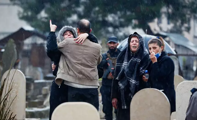 Relatives mourn during the funeral of victims of an attack a day earlier at the Imam Ali bin Abi Talib Mosque in the predominantly Alawite Wadi al-Dhahab neighborhood, at a cemetery on the outskirts of Homs, Syria, Saturday, Dec. 27, 2025. (AP Photo/Omar Sanadiki)