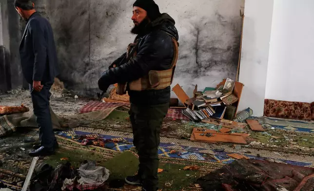 Syrian security officers inspect the site of an attack a day earlier at the Imam Ali bin Abi Talib Mosque in the predominantly Alawite Wadi al-Dhahab neighborhood of Homs, Syria, Saturday, Dec. 27, 2025. (AP Photo/Omar Sanadiki)