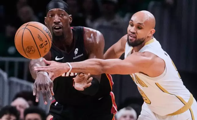 Boston Celtics guard Derrick White, right, pressures Miami Heat center Bam Adebayo, left, during the first half of an NBA basketball game, Friday, Dec. 19, 2025, in Boston. (AP Photo/Charles Krupa)