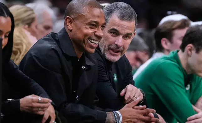 Boston Celtics owner Bill Chisholm, center right, talks with former Celtics guard Isaiah Thomas, center left, during the first half of an NBA basketball game against the Miami Heat, Friday, Dec. 19, 2025, in Boston. (AP Photo/Charles Krupa)